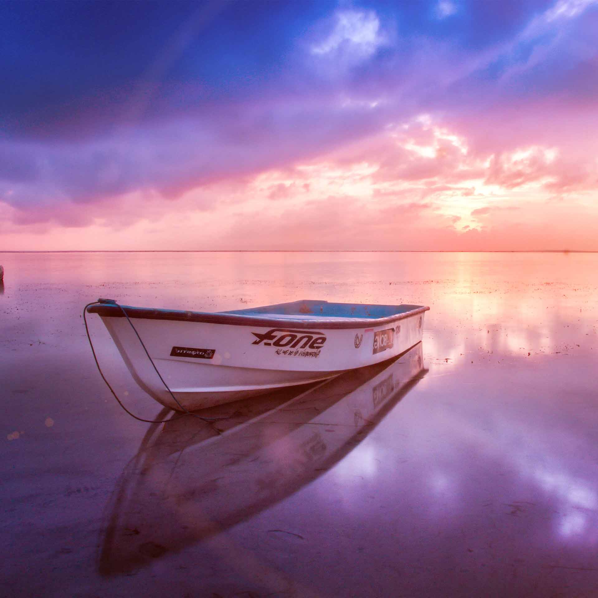 iPhone 或 iPad 上粉色和紫色海洋日落的船