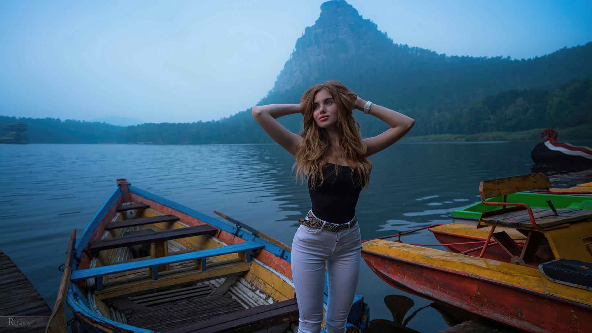 一个女孩在湖边的船上摆姿势 4K