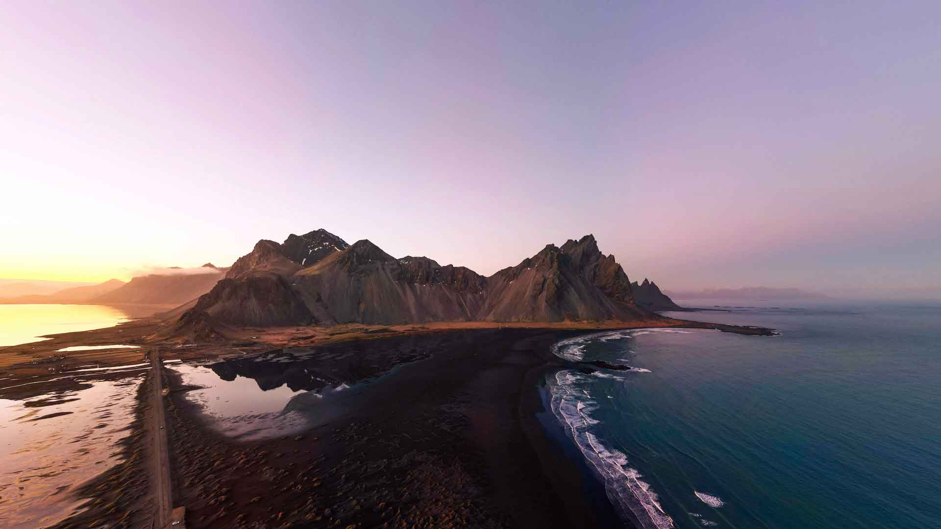 日落黑沙滩海洋和山脉全景