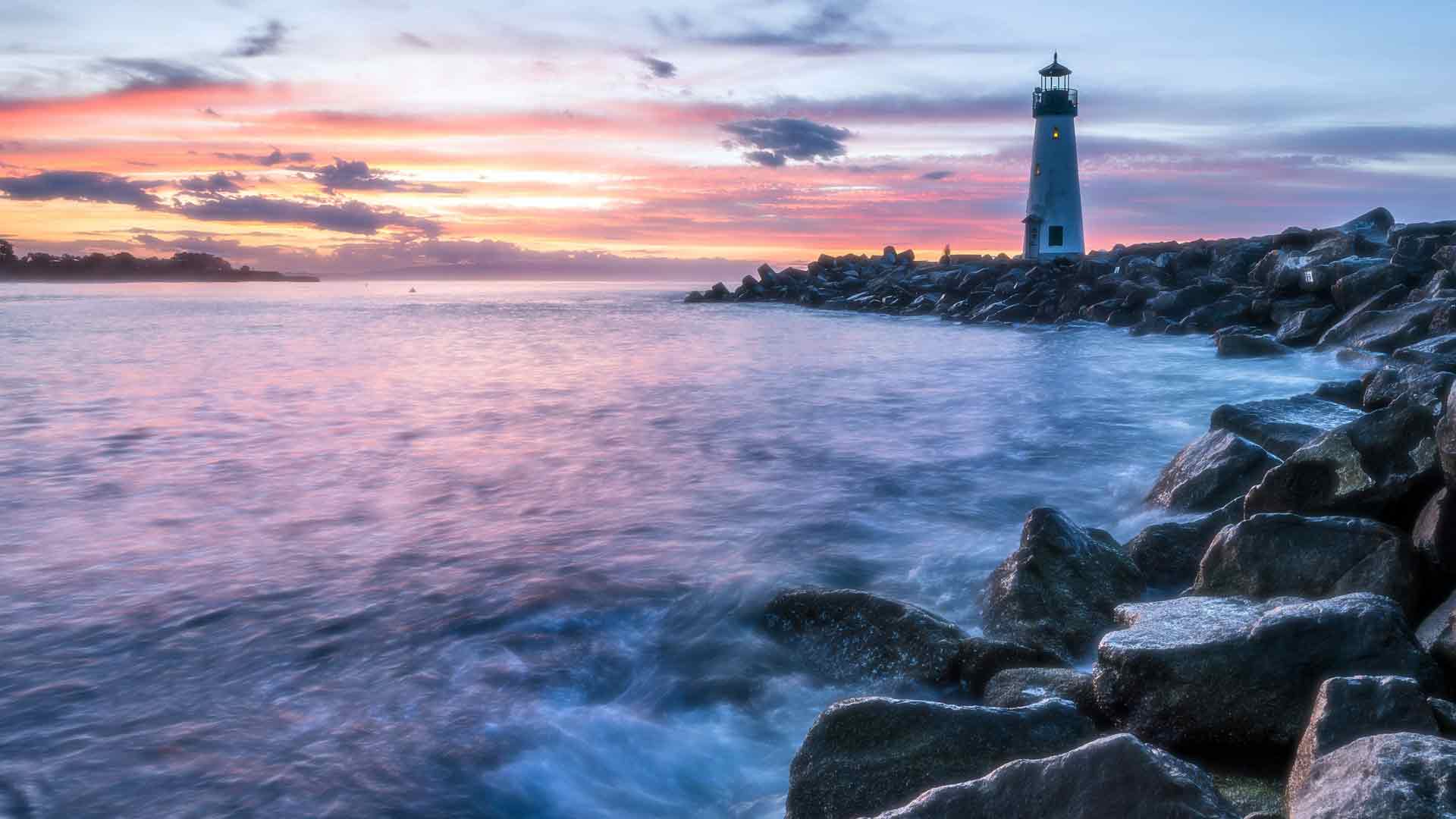海浪孤独的灯塔海岸日落夏季海滩