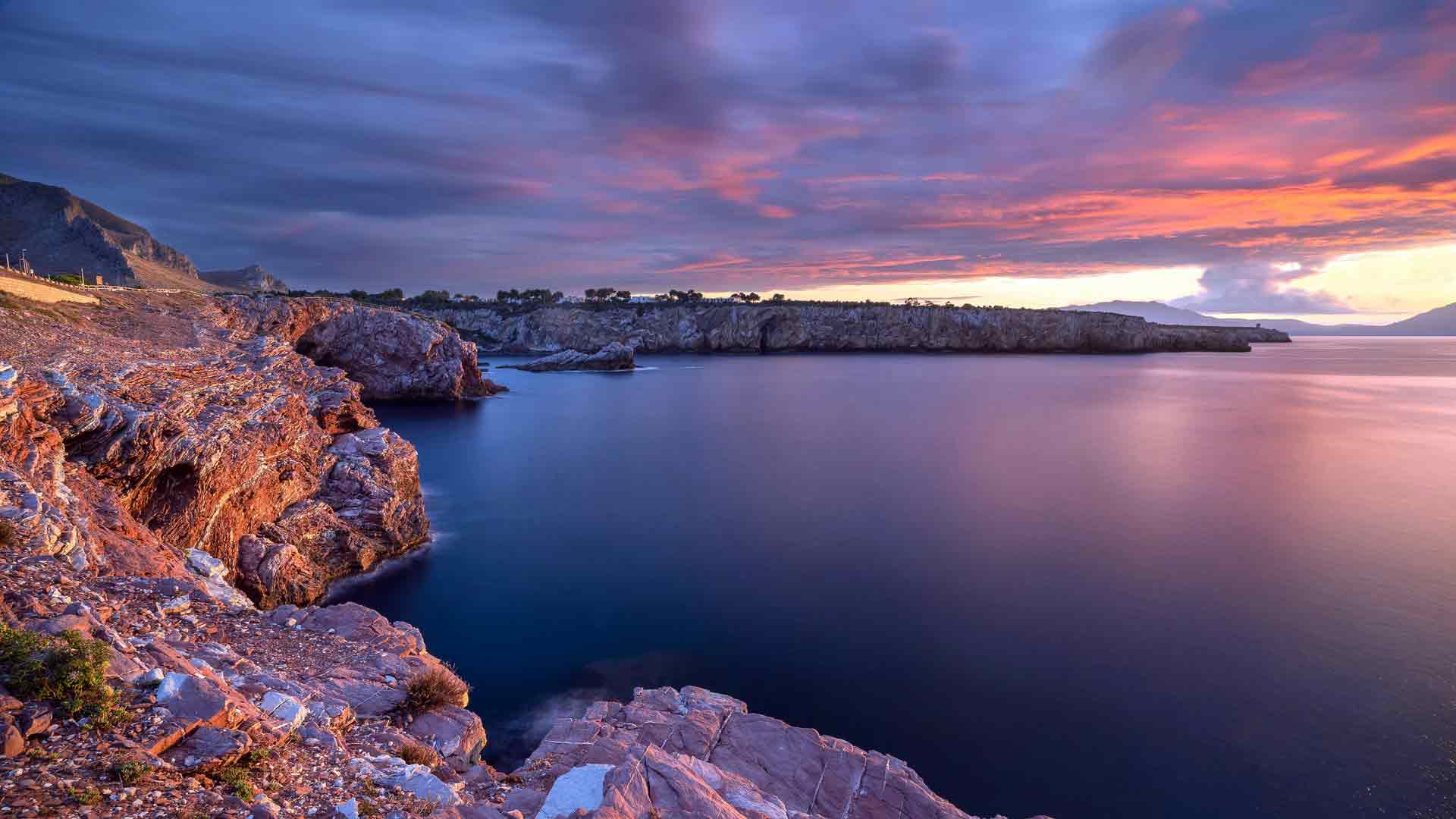 壮丽的日落，岩石海岸线，平静的海洋
